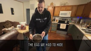 The Bag We Had to Hide — Nutra Complete Freeze-Dried Raw Dog Food Ryan Harden in a homestead kitchen holds a metal bowl of Nutra Complete freeze-dried raw beef cubes, with the bag on the table behind him. Overlay text reads: The bag we had to hide.