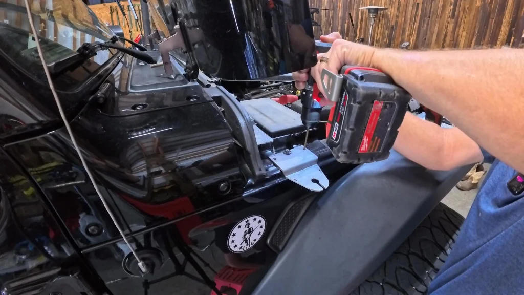 Drilling a pilot hole through the Jeep fender for the antenna bracket.